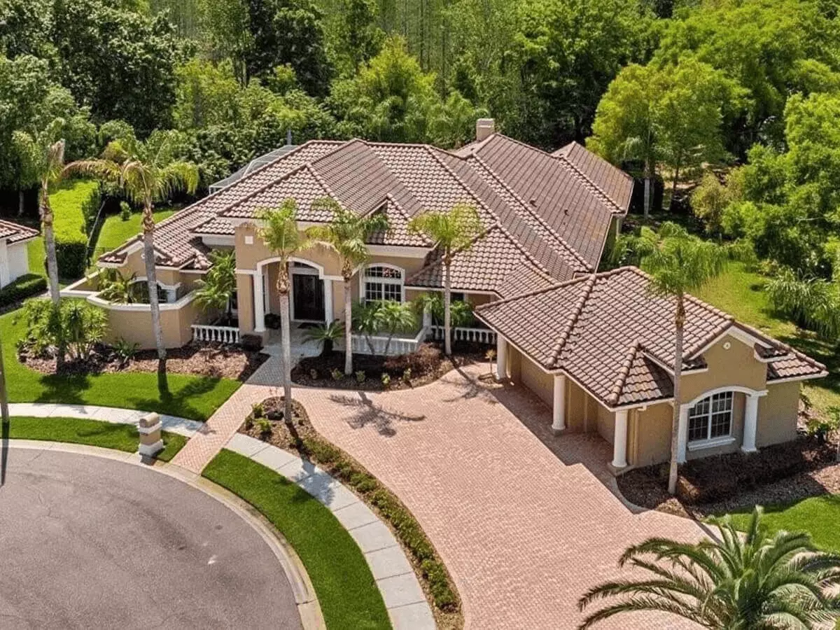 Aerial front view of a Mediterranean style home on a cul de sac surrounded by luxurious palms