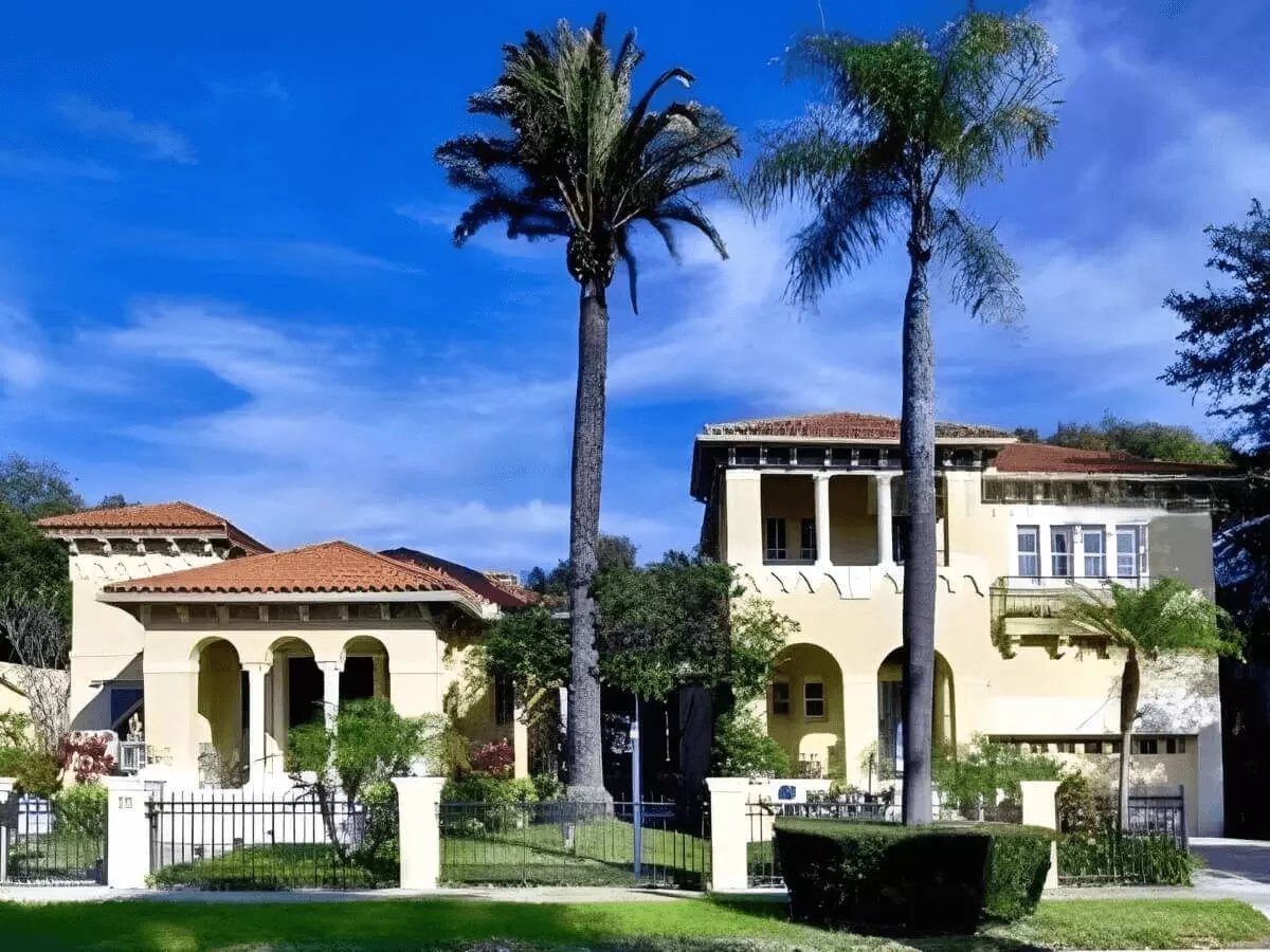 Front view of a luxury estate with towering palms and professional landscaping